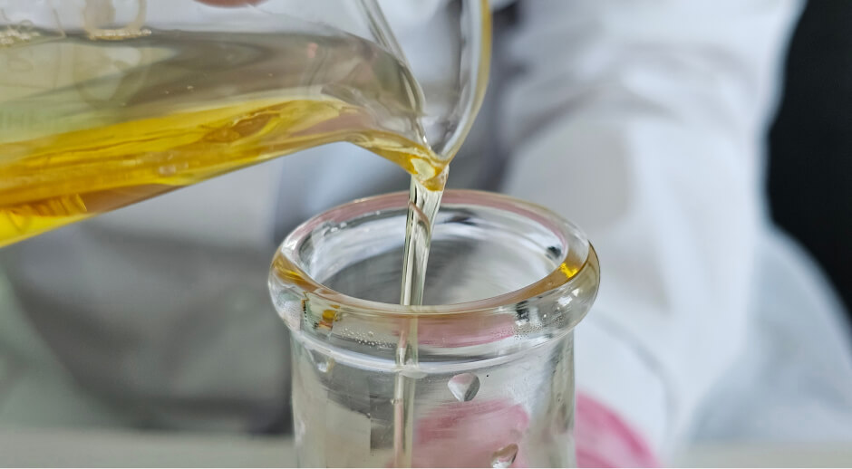 Synthetic base oil poured into a lab beaker